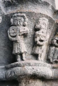 Stein Relief in Källunge: Je 2 Personen spielen auf ihrem Nyckelharpa Instrument.