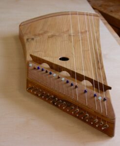 Namen von Musikinstrumenten Zither. Wir sehen eine kleine Kastenzither