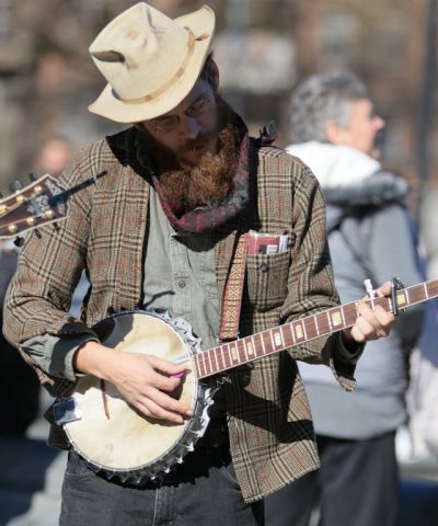 Straßenmusiker spielt das gitarrenähnliche Instrument Banjo.